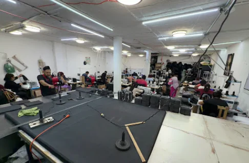 Taller de confección de Emmeisy: mesa de corte y líneas de máquinas de coser en operación